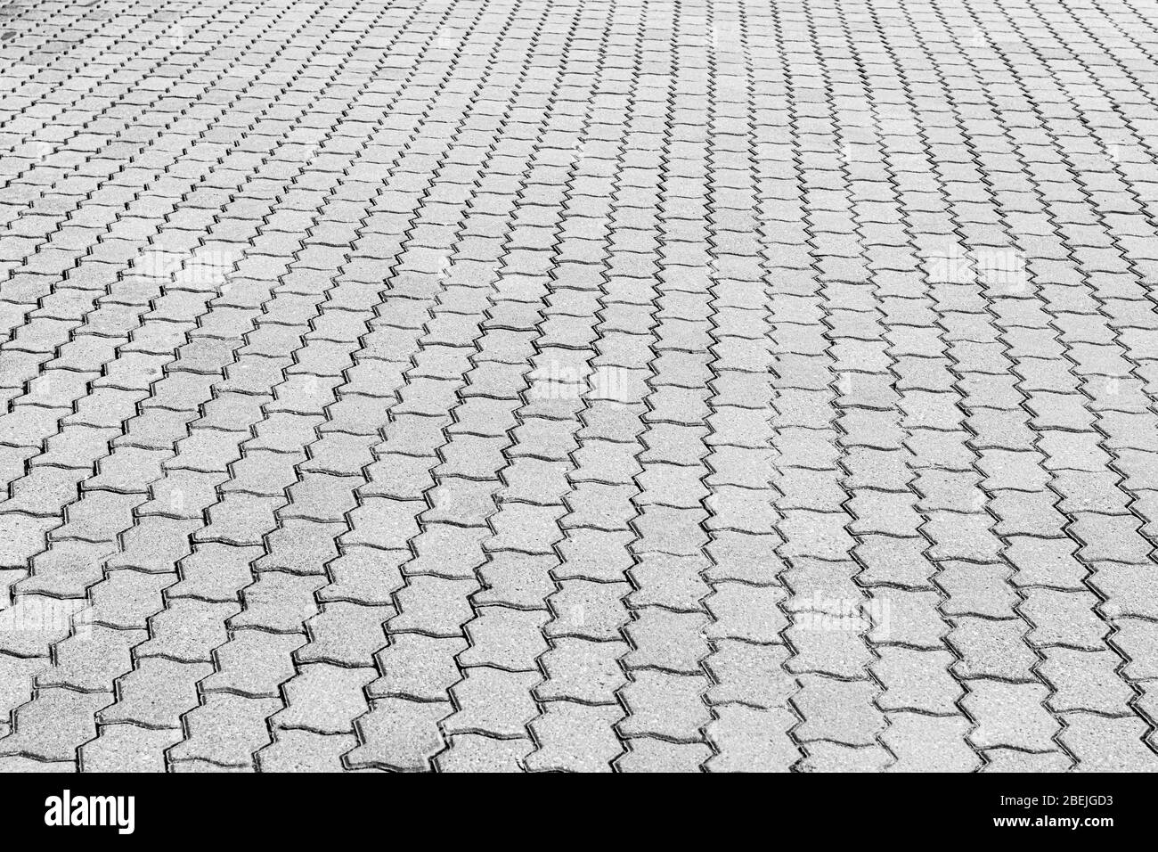 Top view on black and white paving stone road. Old pavement of granite