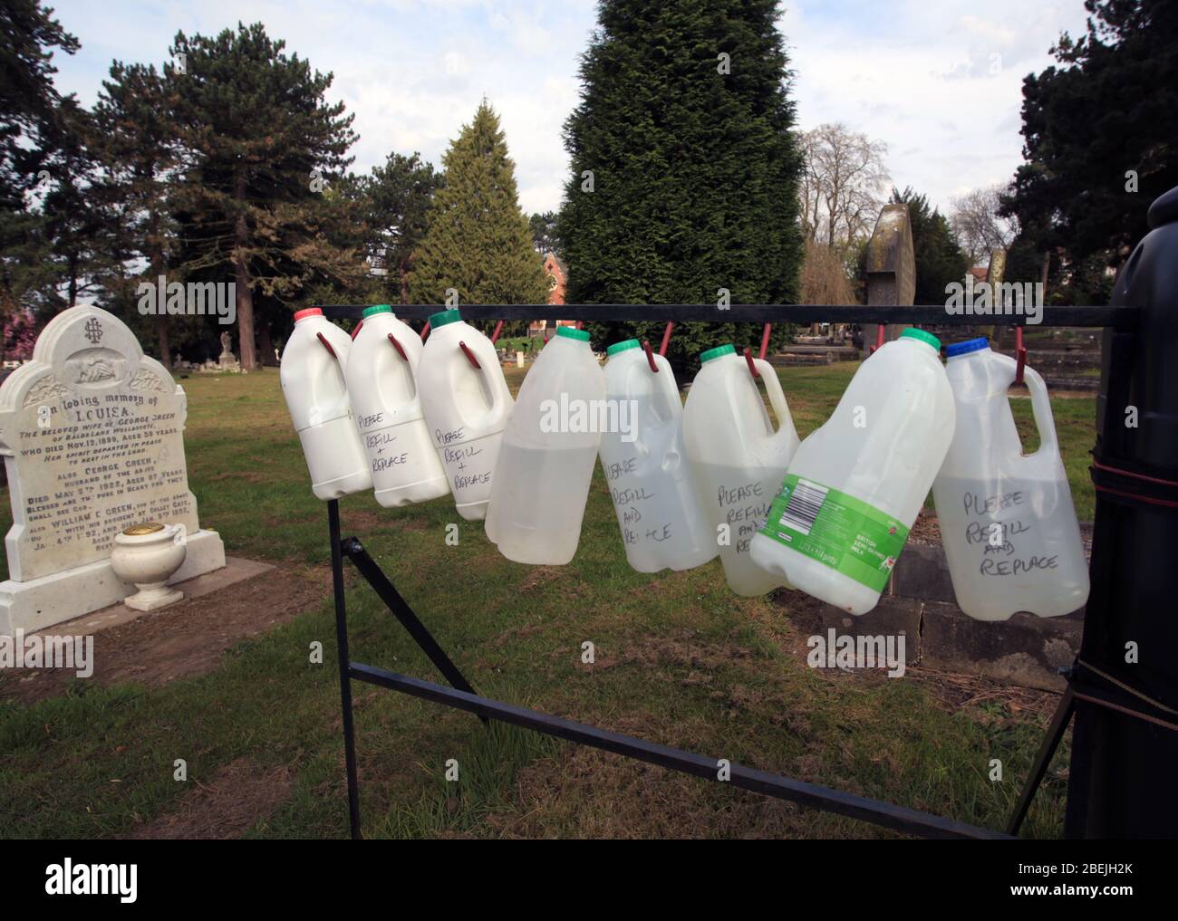 Bottles of water to water flowers on graves in Lye and Wollescote cemetery, Stourbridge, West midlands, UK. Stock Photo