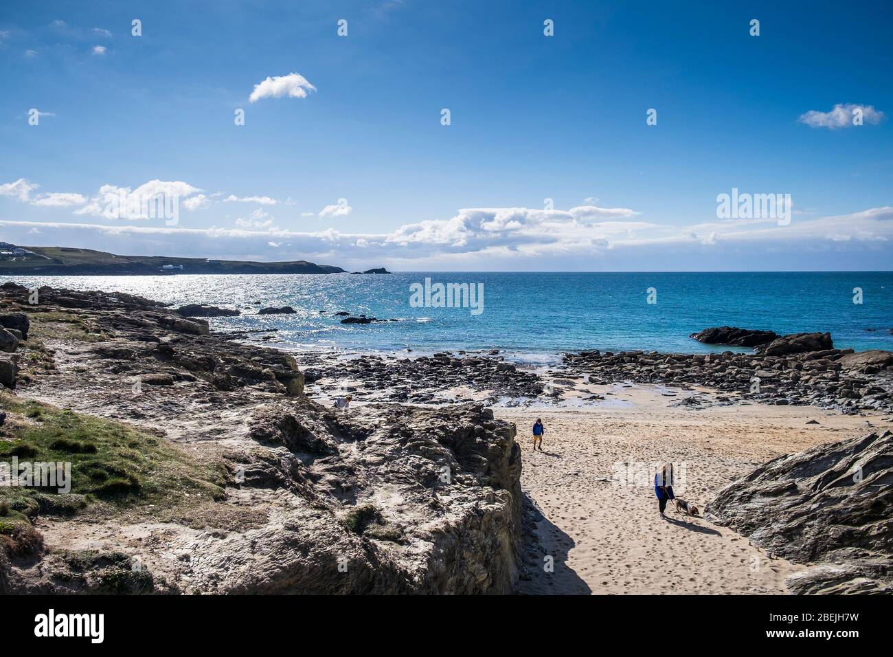 People walking across the sand at the secluded Little Fistral in Newquay in Cornwall. Stock Photo