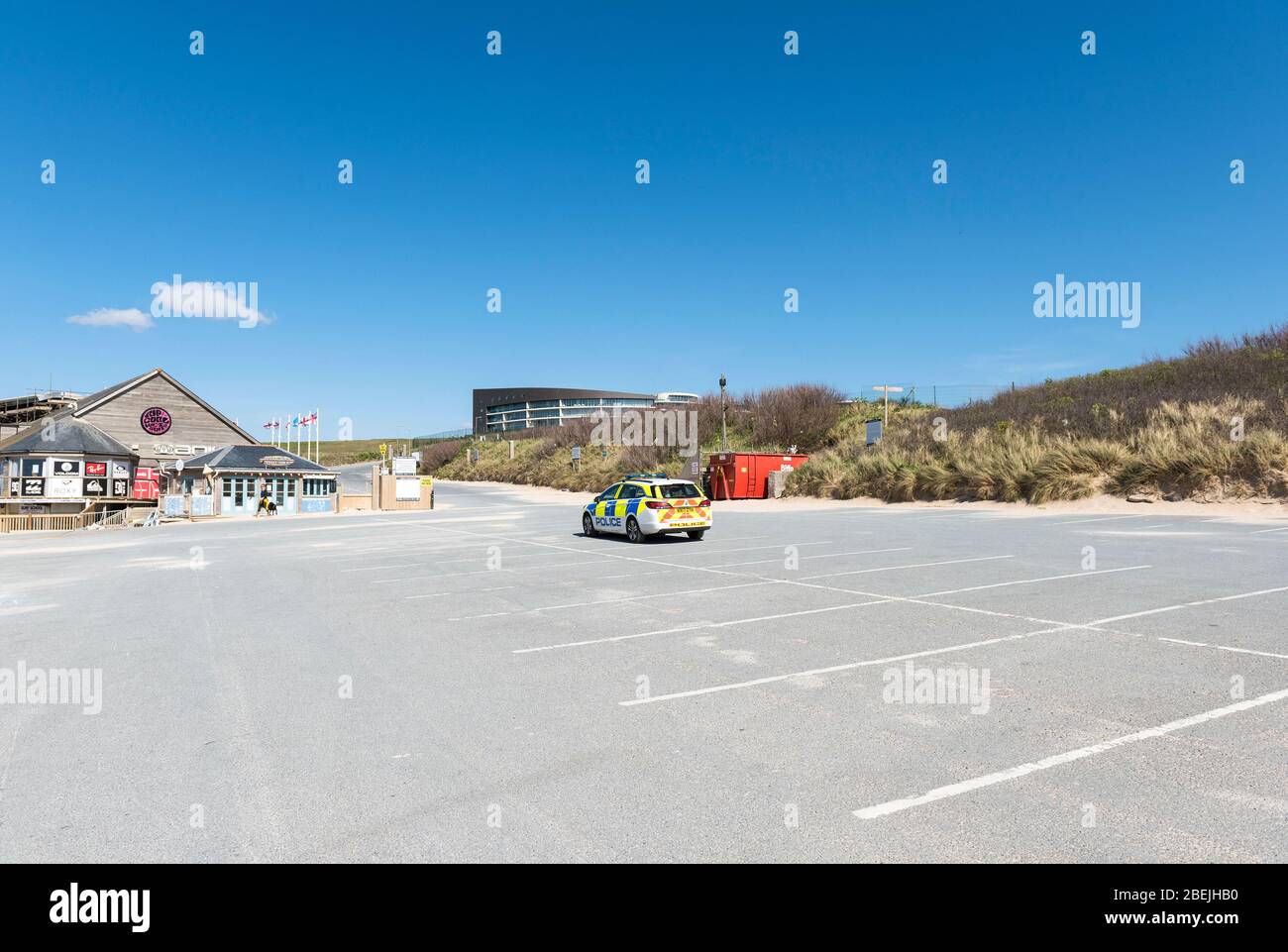 A Devon and Cornwall Police car parked in an empty Fistral car park during the lockdown caused by the Coronavirus Covid 19 pandemic. Stock Photo
