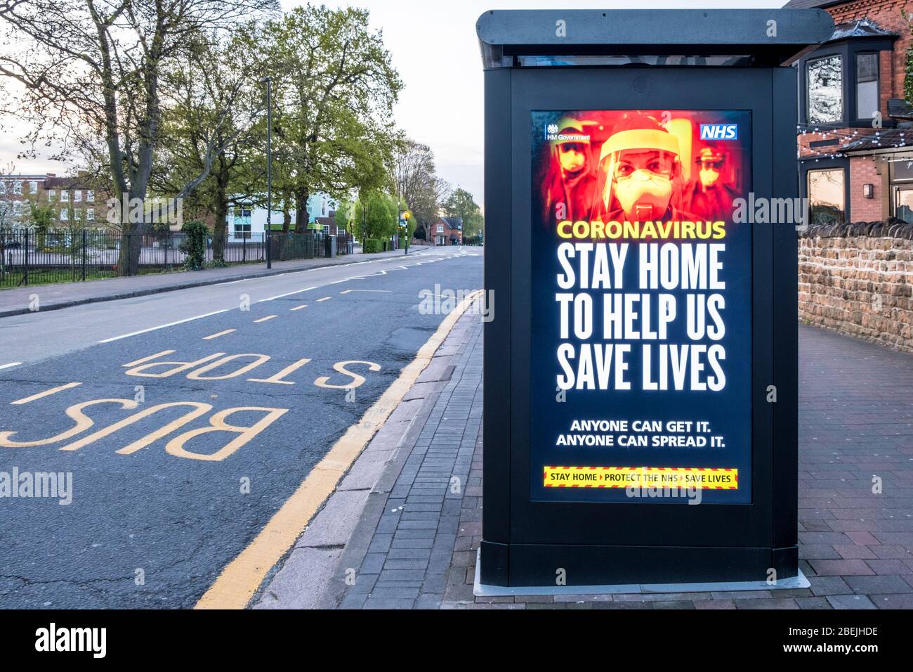 Coronavirus. Stay home to help us save lives. Covid-19 lockdown message on a bus stop shelter on an empty street, Nottinghamshire, England, UK Stock Photo