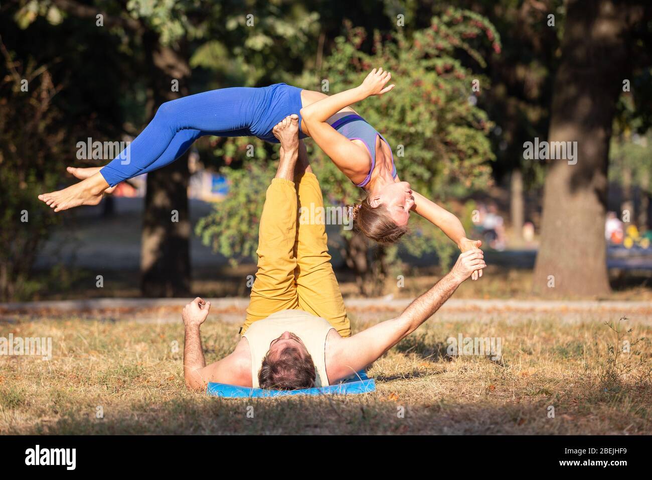 Two athletes performing duo acroyoga poses Stock Photo by Photology75