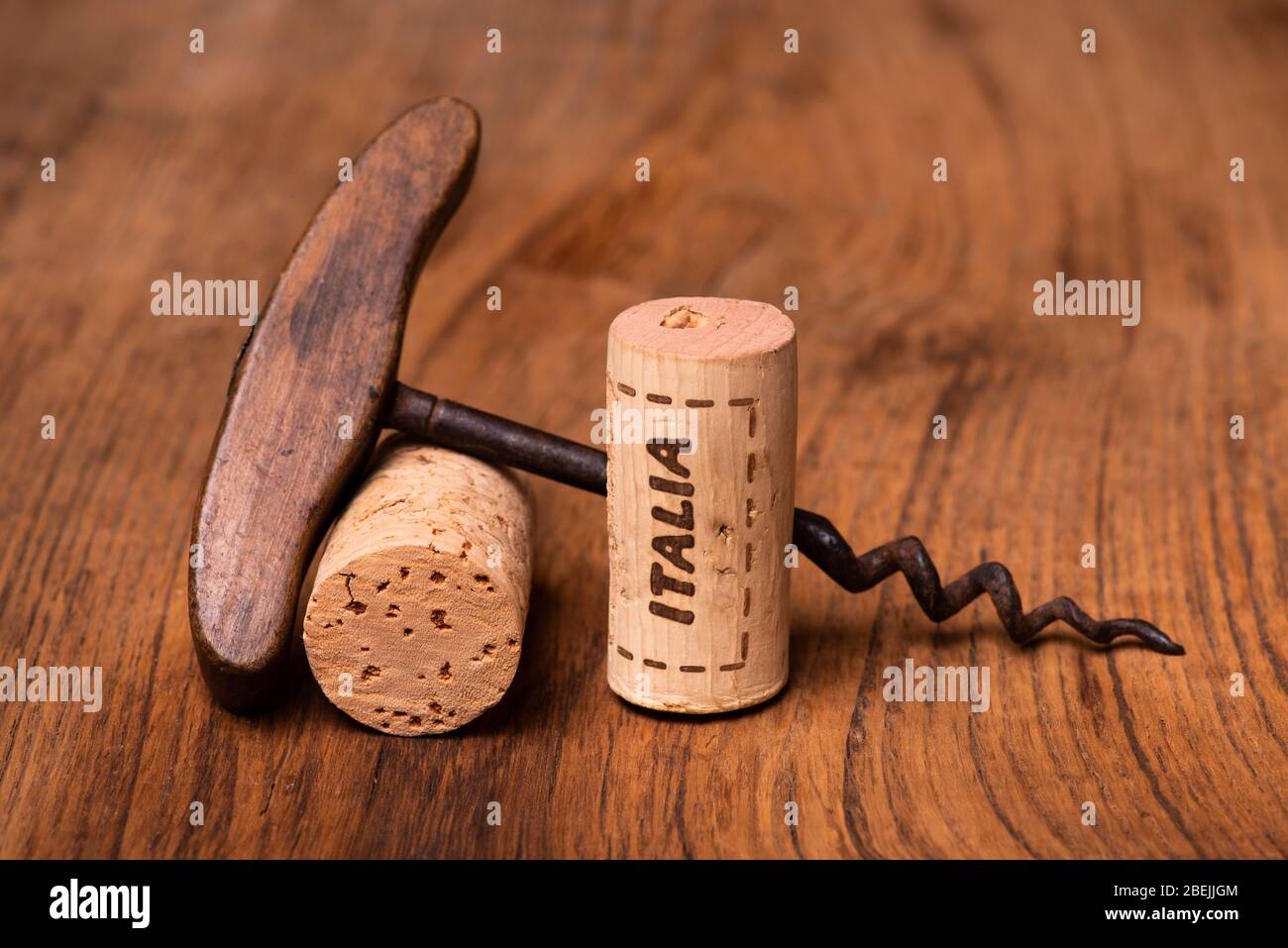 in the foreground, on raw wood, Italian wine corks and vintage corkscrews Stock Photo