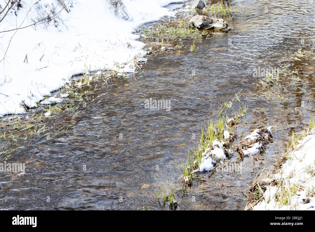 A melting or freezing stream in late autumn or early spring on a sunny ...