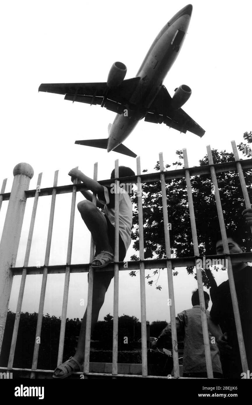 Citizens watching the plane taking off from Guangzhou Baiyun Airport and the airport fence Stock Photo