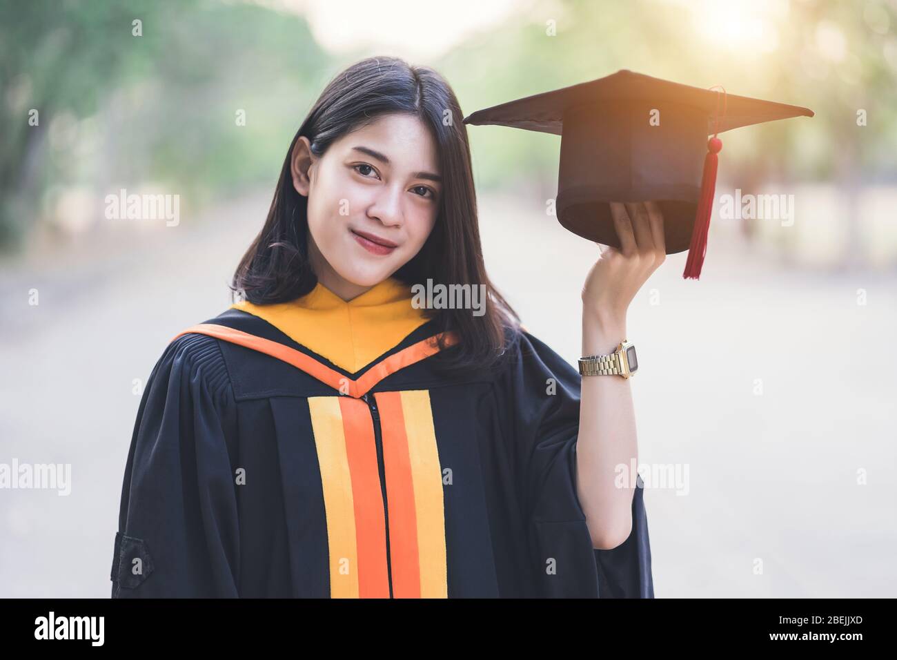 Young charming Asian feemale gradutes cerebrate her degree graduation after accomplish diploma certificate in commencement day. Congratulations on Edu Stock Photo