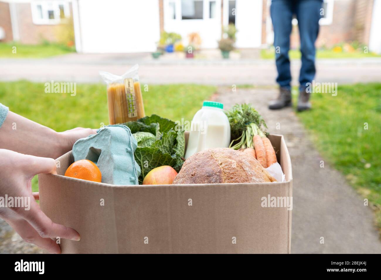Close Up Of Home Delivery Of Fresh Produce Outside House Observing Safe Social Distancing During Coronavirus Covid-19 Pandemic Stock Photo