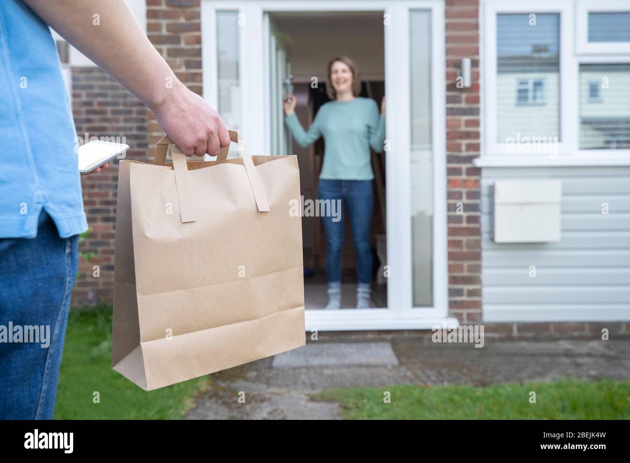 Home Delivery Of Takeaway Food Outside House Observing Safe Social