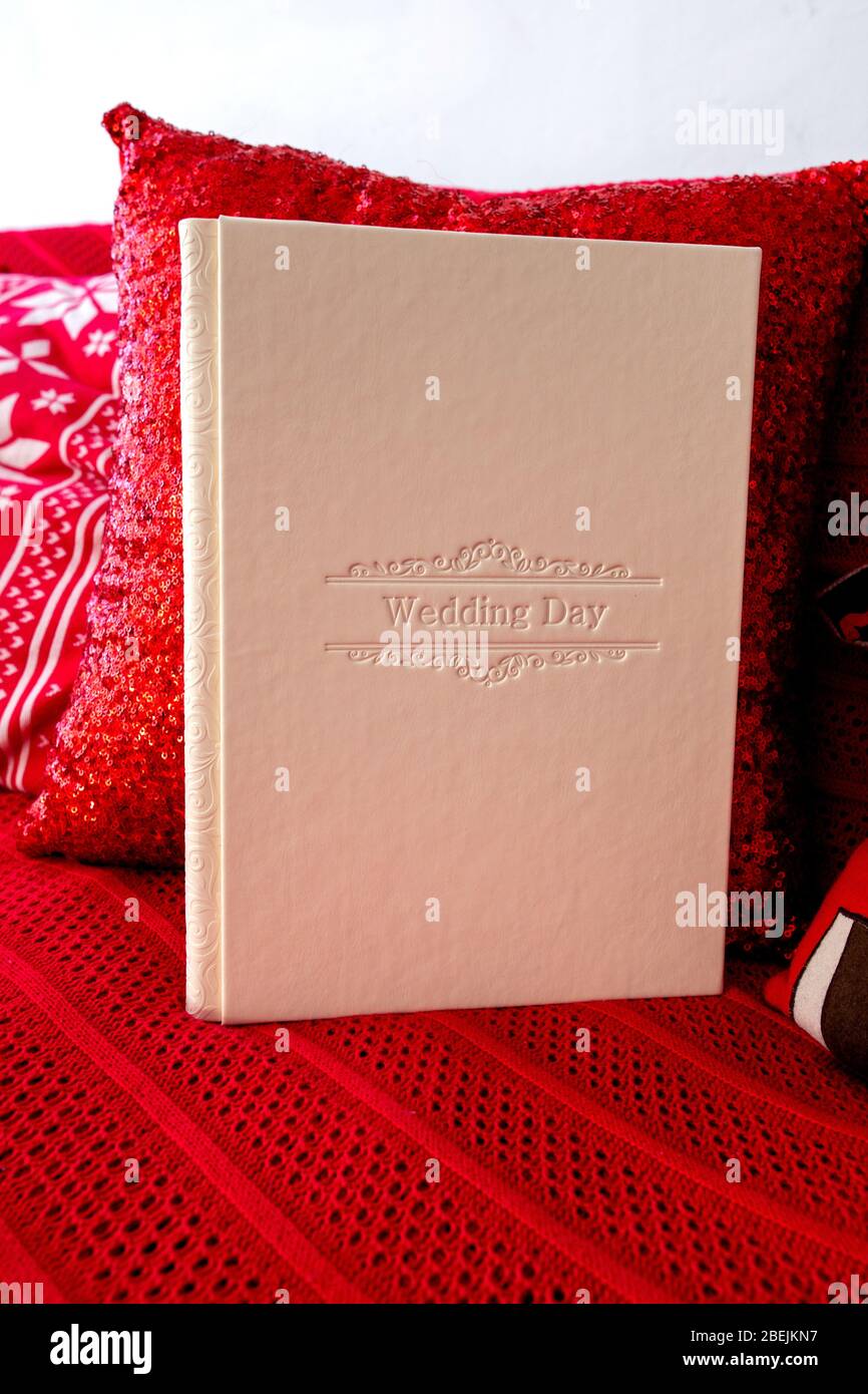 Photo album with a box on a wooden background. Photo book with embossing. photobook with a gift box Photo album with a hard cover Bright red photoalbu Stock Photo
