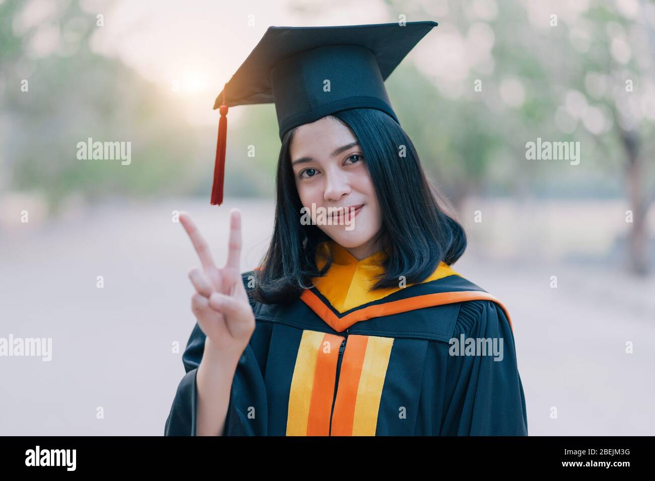 Young charming Asian feemale gradutes cerebrate her degree graduation after accomplish diploma certificate in commencement day. Congratulations on Edu Stock Photo