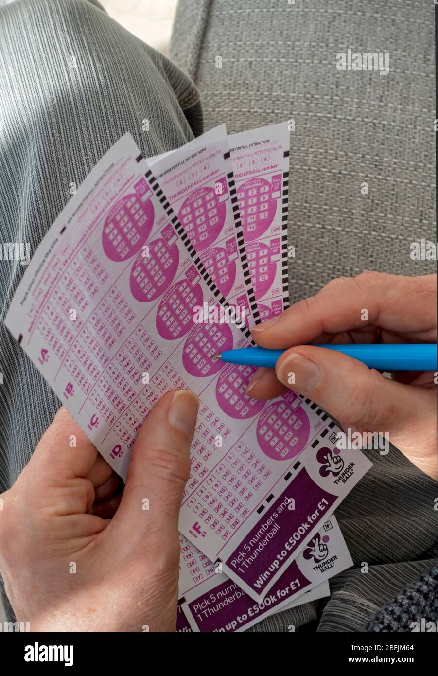 Close up of person man holding filling in Thunderball Lotto lottery slip form England UK United Kingdom GB Great Britain Stock Photo