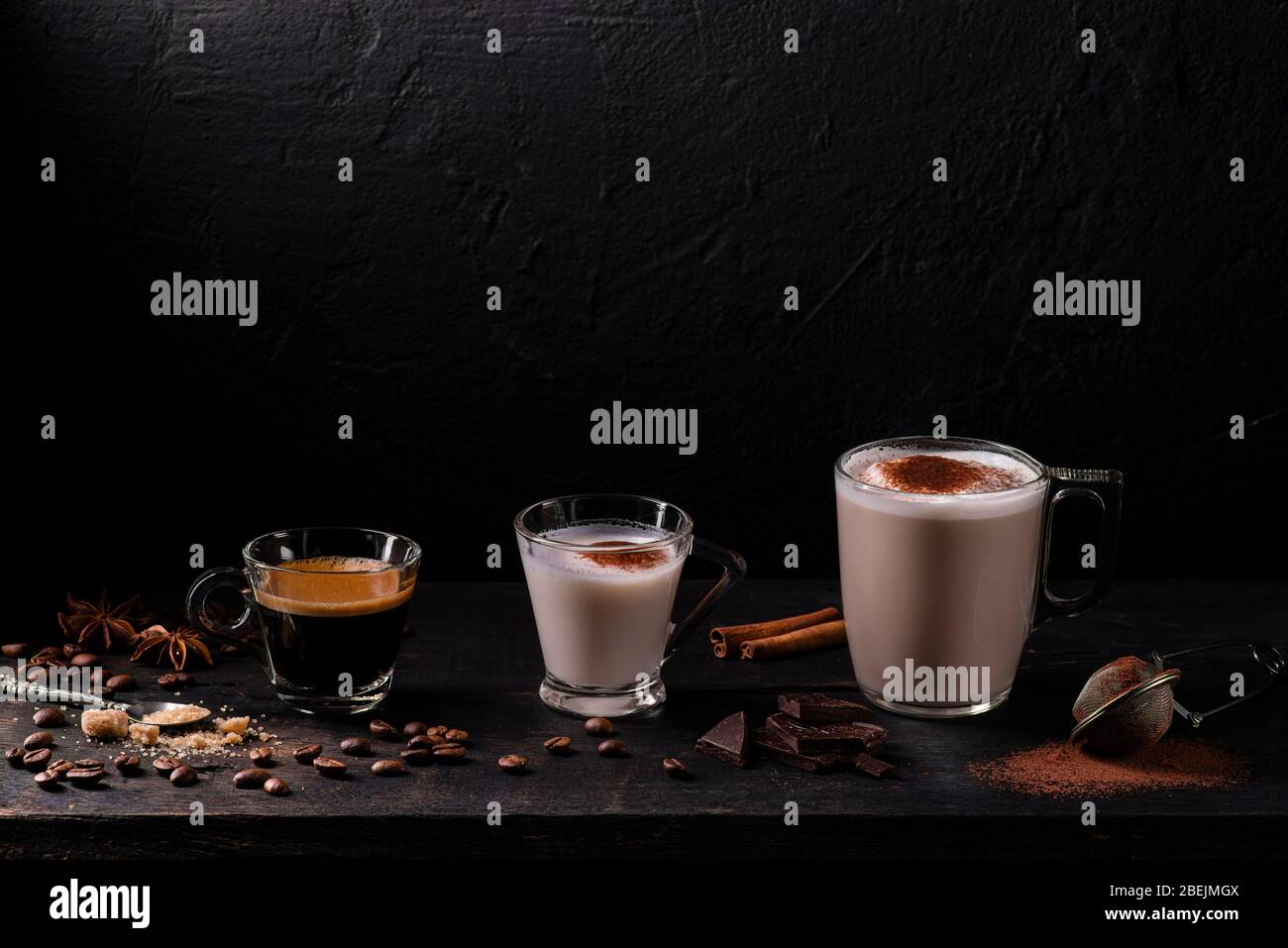 in the foreground, some types of espresso, latte macchiato and cappuccino with a sprinkling of cocoa powder. Stock Photo