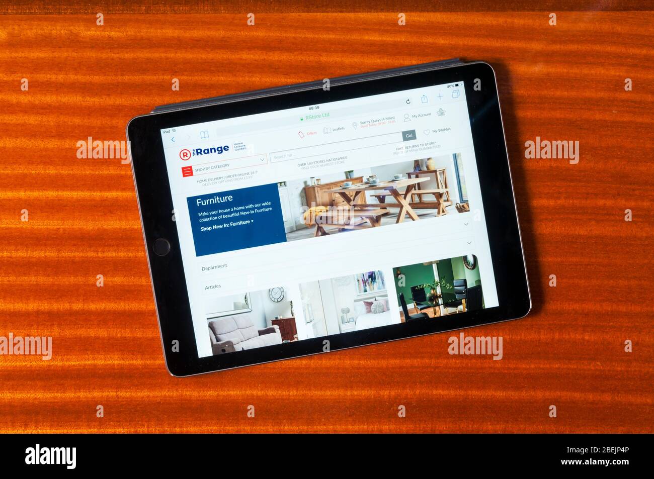 The website of The Range furniture sellers displayed on an iPad tablet computer against a polished wood background. Stock Photo