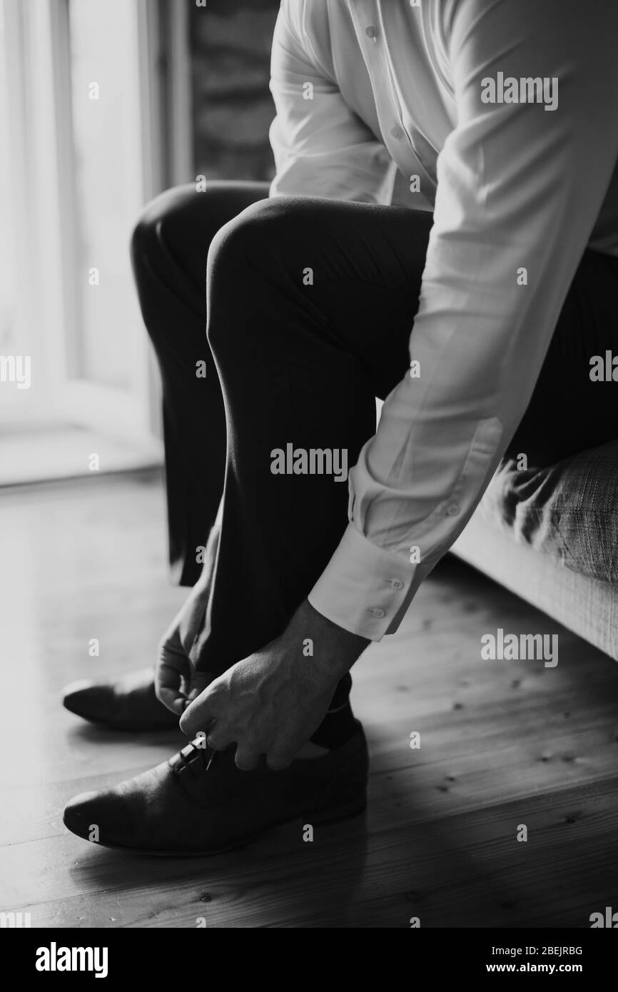 man wearing shoes at home. Wearing shoes close up shot. Monochrome Stock Photo
