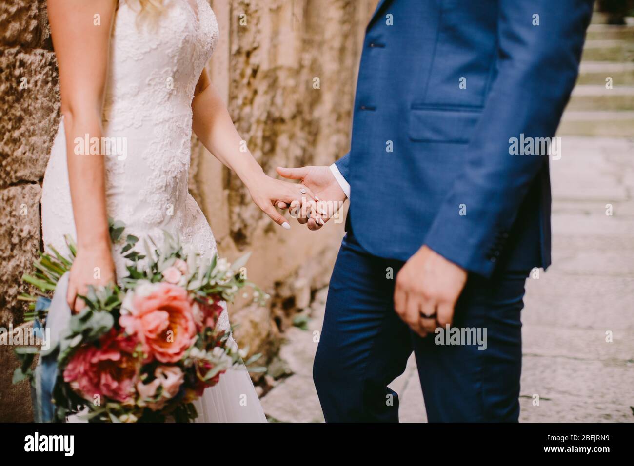 wedding couple holding hands with engagement ring close up. Bride and ...