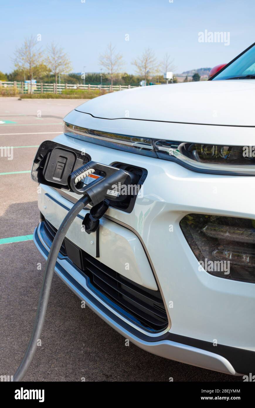 New electric car Kia E Soul registered march 2020 electric car charging at a public electric car charger plugged into a rapid car charging unit Stock Photo