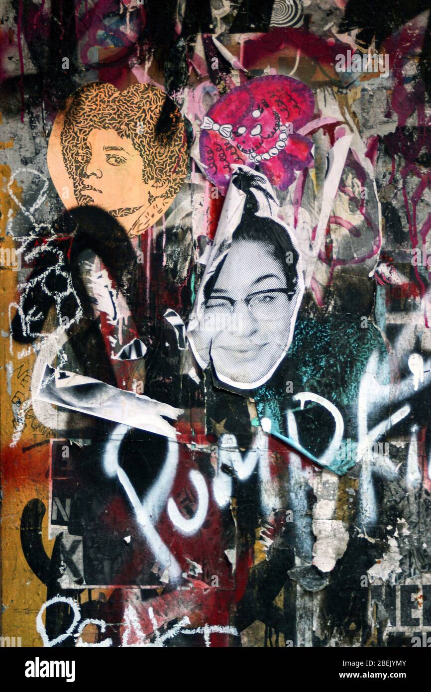Accidental collage art as graffiti tags, stickers and cut-to-shape posters are put on each other in Lower East Side, New York City, United States Stock Photo