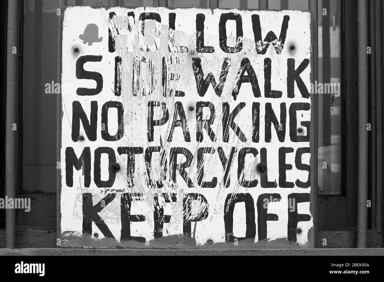 Hollow sidewalk. No parking. Motorcycles keep off. Hand painted sign on a window in Manhattan, New York City, United States of America. Stock Photo