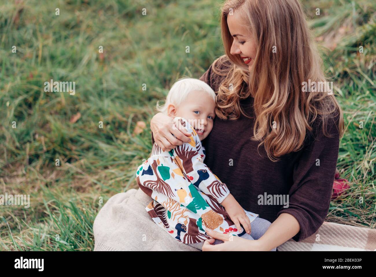 Cute mom hugs and toddler daughters. Family lifestyle in nature. Stock Photo