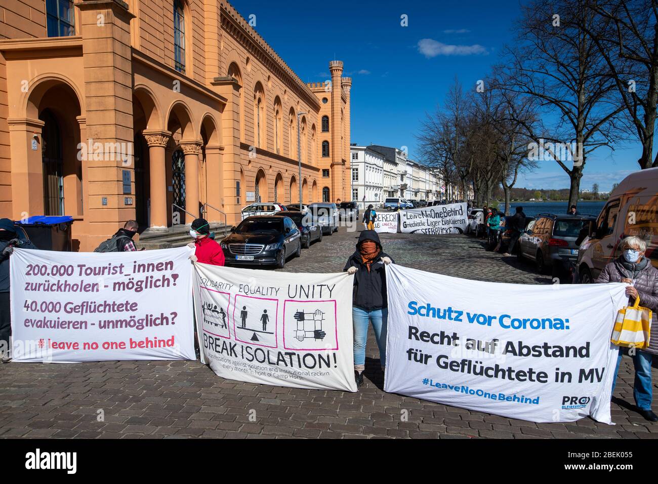 14 April 2020, Mecklenburg-Western Pomerania, Schwerin: Members of the  Initiative Pro Bleiberecht (Initiative for the Right to Stay) demonstrate,  among other things, with a poster 