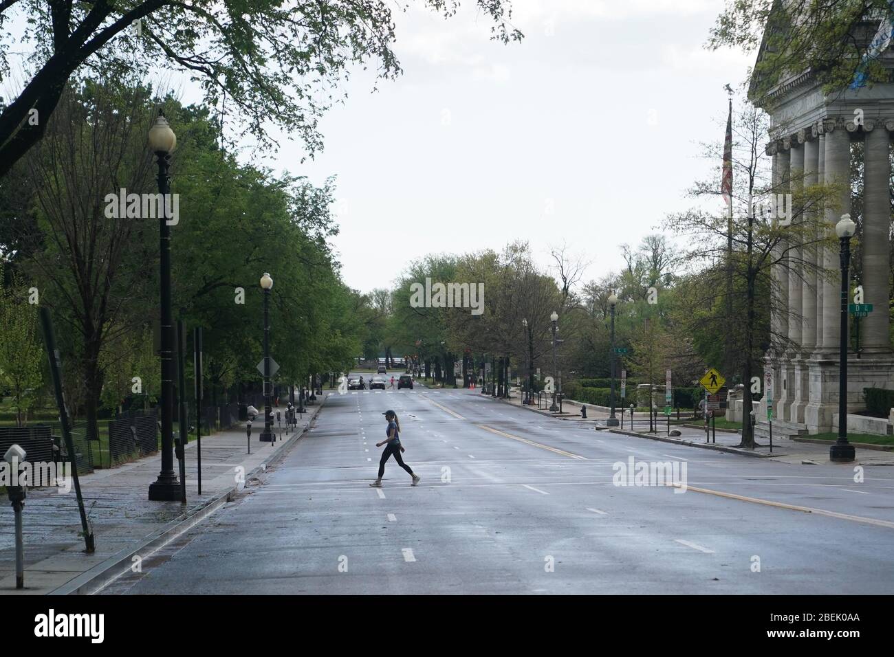 Washington, DC, USA. 13th Apr, 2020. A woman crosses an empty street in Washington, DC, the United States, April 13, 2020. Credit: Liu Jie/Xinhua/Alamy Live News Stock Photo