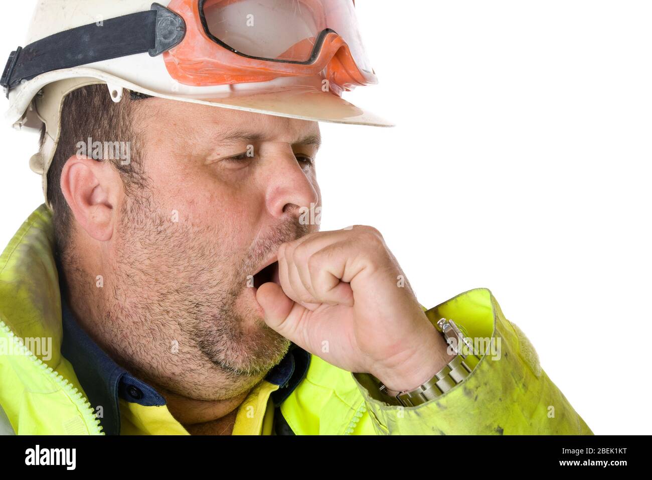 A worker yawning and covering his mouth. Stock Photo