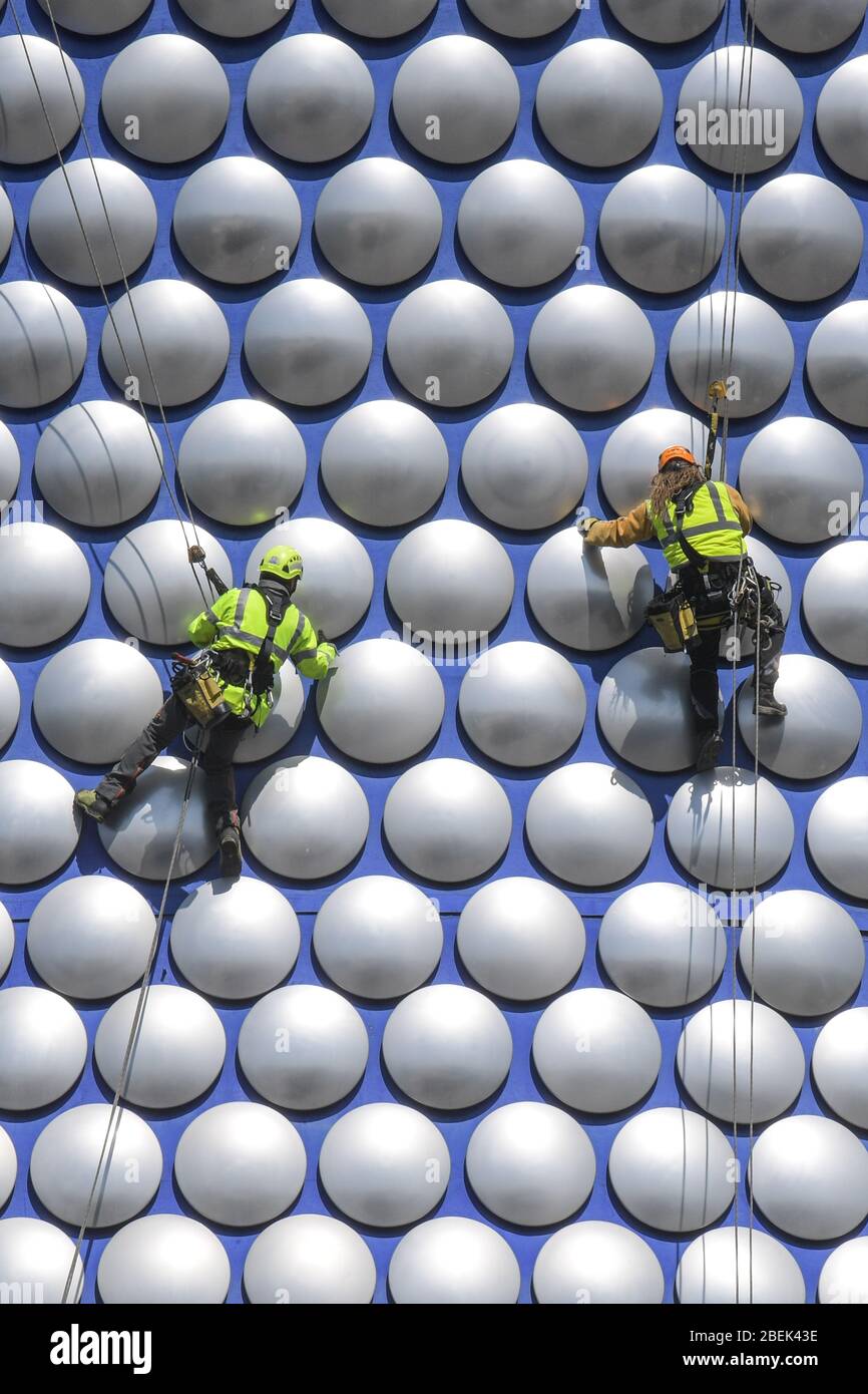 Birmingham, West Midlands, UK. 14th Apr, 2020. Workmen abseil down the exterior of Selfridges in Birmingham city centre to check if any of the discs are loose. The workers have used the lockdown to work without causing major disruption to pedestrians below. Credit: Sam Holiday/Alamy Live News Stock Photo