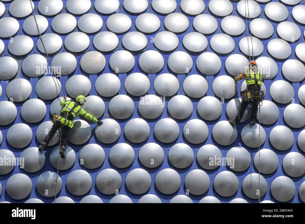 Birmingham, West Midlands, UK. 14th Apr, 2020. Workmen abseil down the exterior of Selfridges in Birmingham city centre to check if any of the discs are loose. The workers have used the lockdown to work without causing major disruption to pedestrians below. Credit: Sam Holiday/Alamy Live News Stock Photo