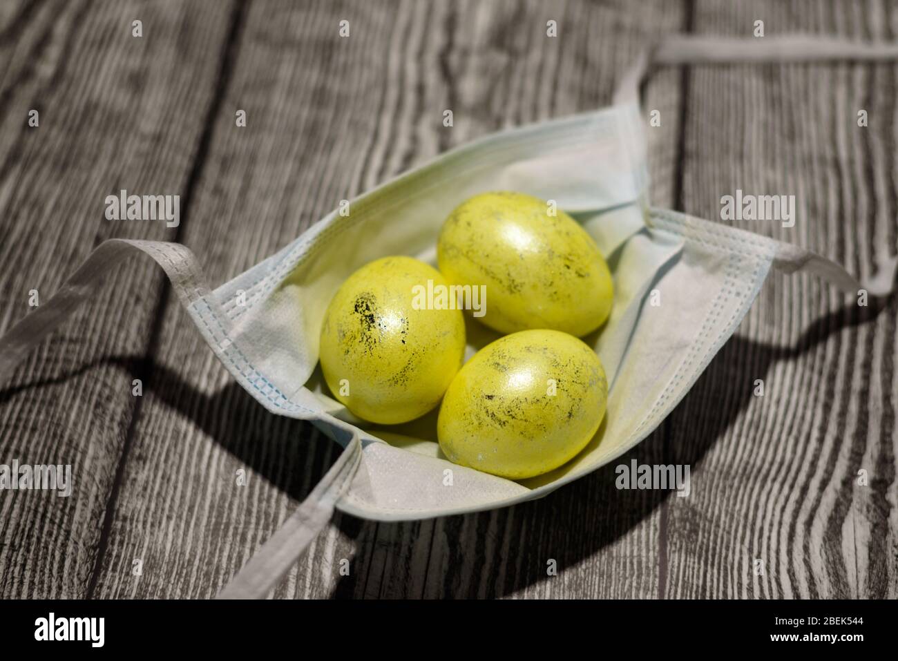 Download Three Colored Yellow Easter Eggs Laying In Medical Mask On The Wooden Background Coronavirus Covid 19 Concept Photo Easter 2020 Stock Photo Alamy PSD Mockup Templates