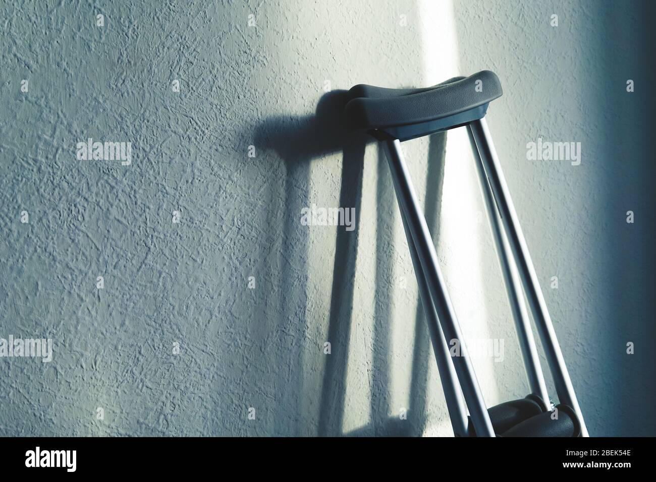 Close up image of crutches are standing against the wall. Place for text. Stock Photo