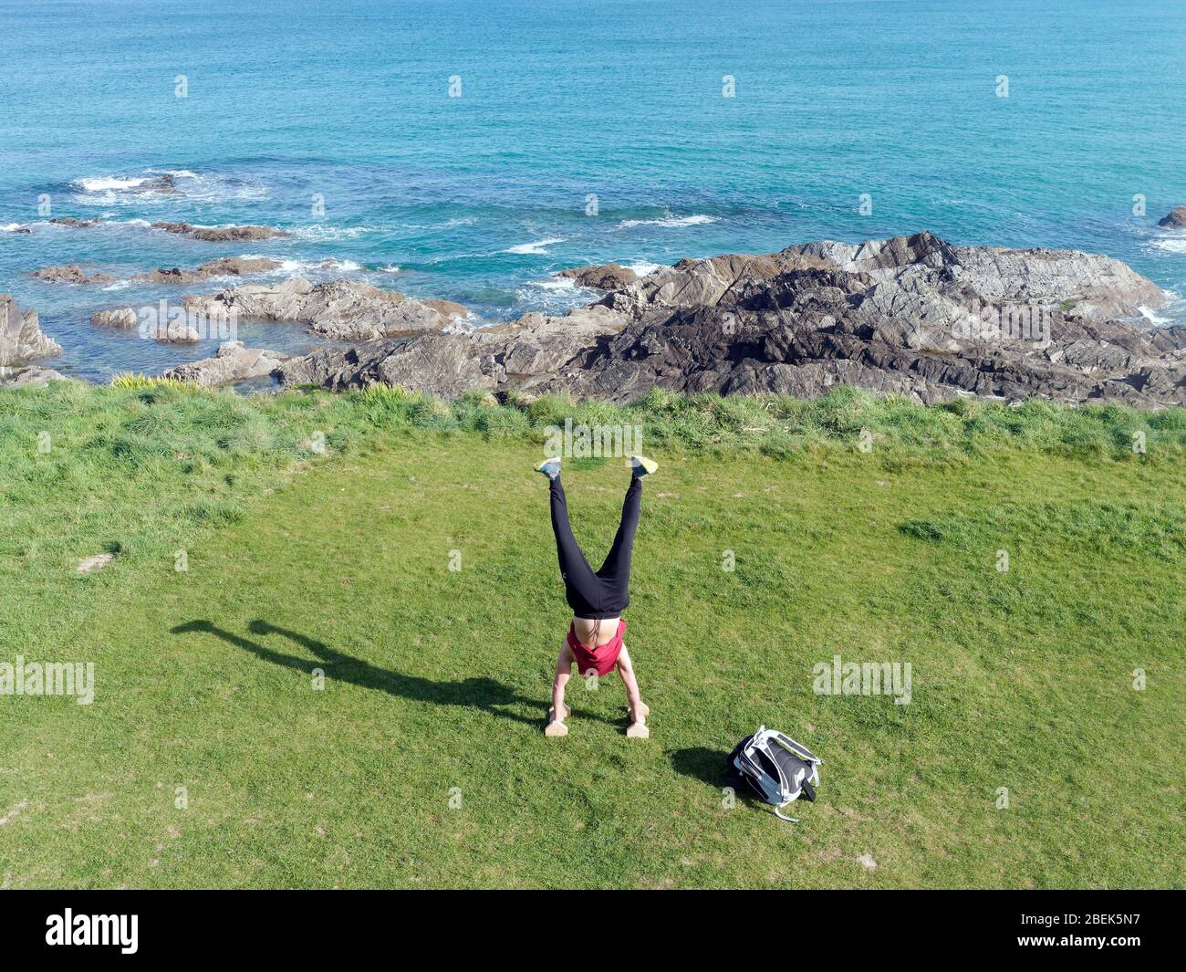 Newquay,Cornwall, 14th April 2020. UK weather: Sunshine and handstands during outdoor morning workout at Fistral Bay. Credit: Robert Taylor/Alamy Live News” Stock Photo