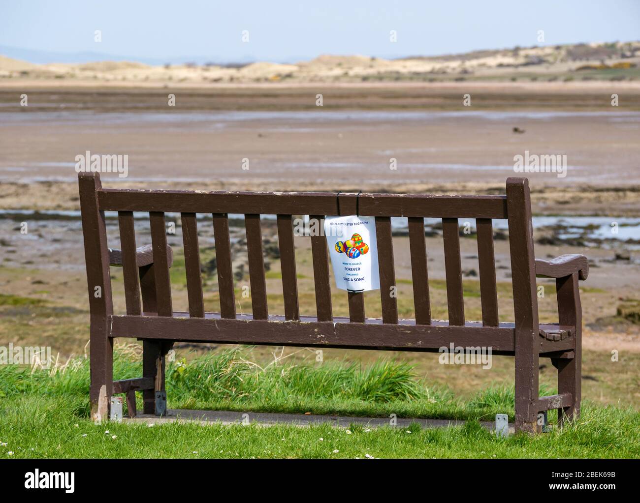 Bench with notice for Aberlady Easter egg hunt during Coronavirus Covid-19 pandemic lockdown, East Lothian, Scotland, UK Stock Photo