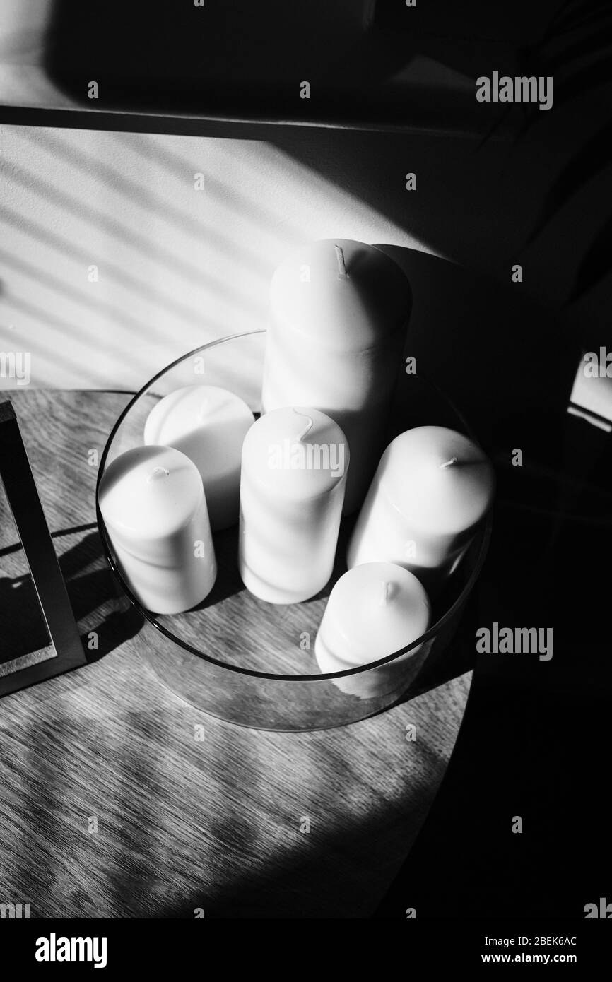 Candles in the living room with strong shadows in black and white Stock Photo