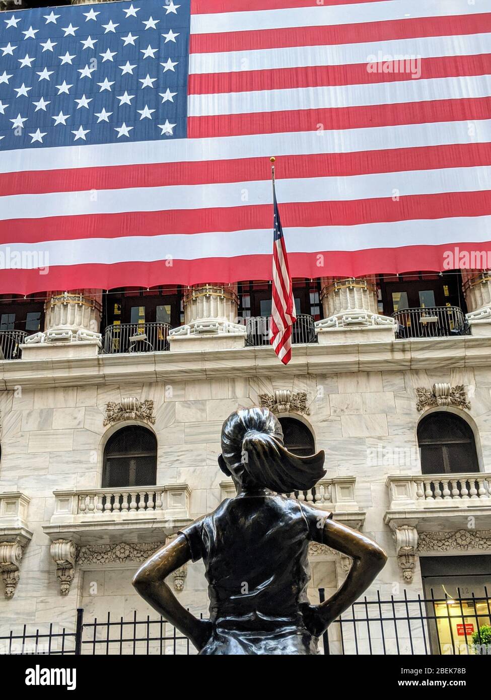 New York Stock Exchange Building and Fearless Girl Statue during the coronavirus pandemic in Lower Manhattan. Stock Photo