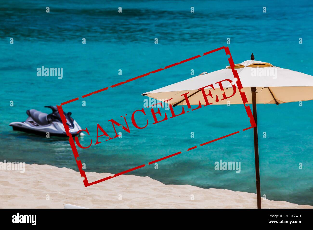 Umbrella with jet ski, beach sand and ocean with text cancelled Stock