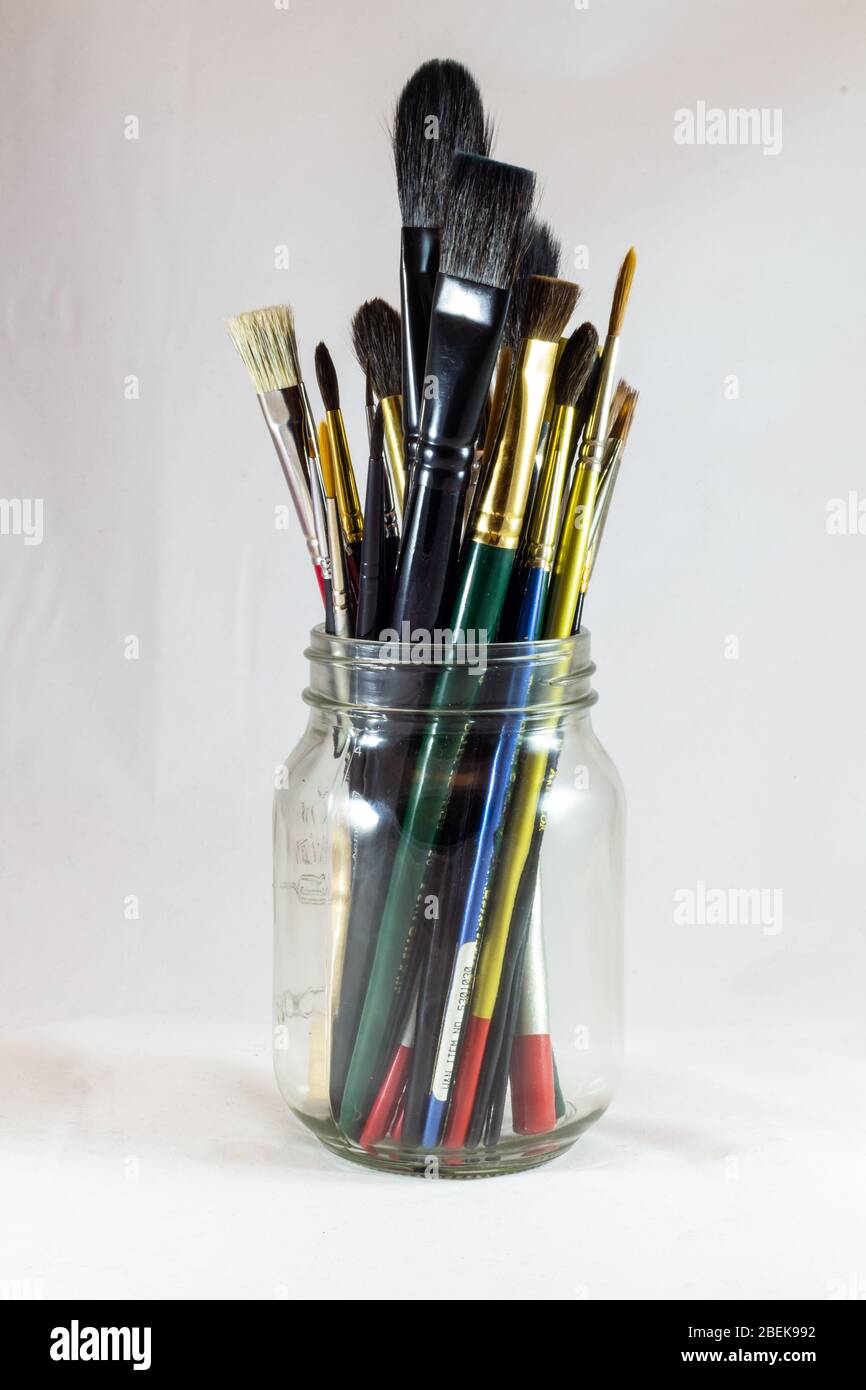 Painting palette and paint brush in glass jar on wooden table or  windowsill. Art still life Stock Photo by seregam