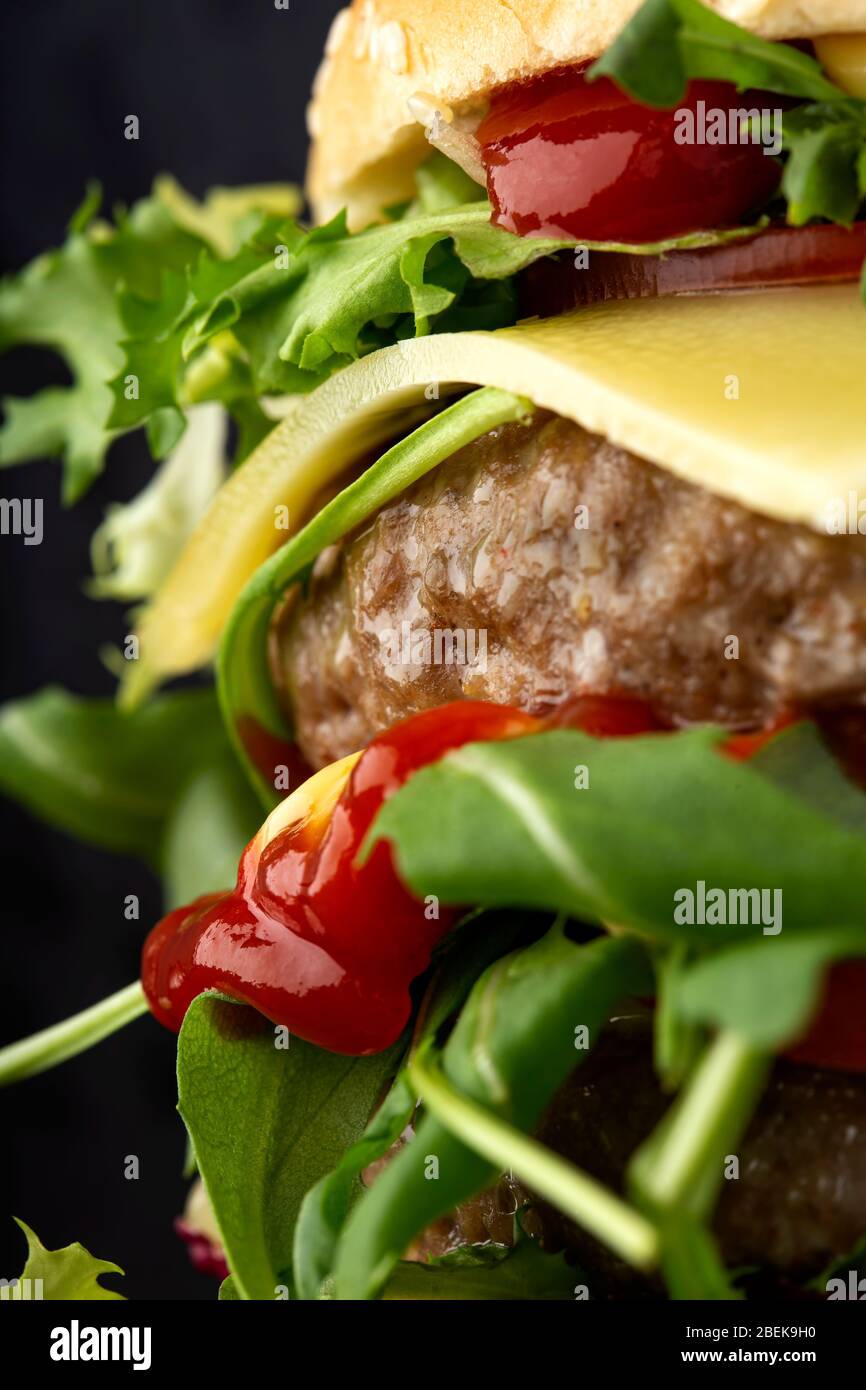 Double cheeseburger with a lot of arugula and sauces - close up view Stock Photo