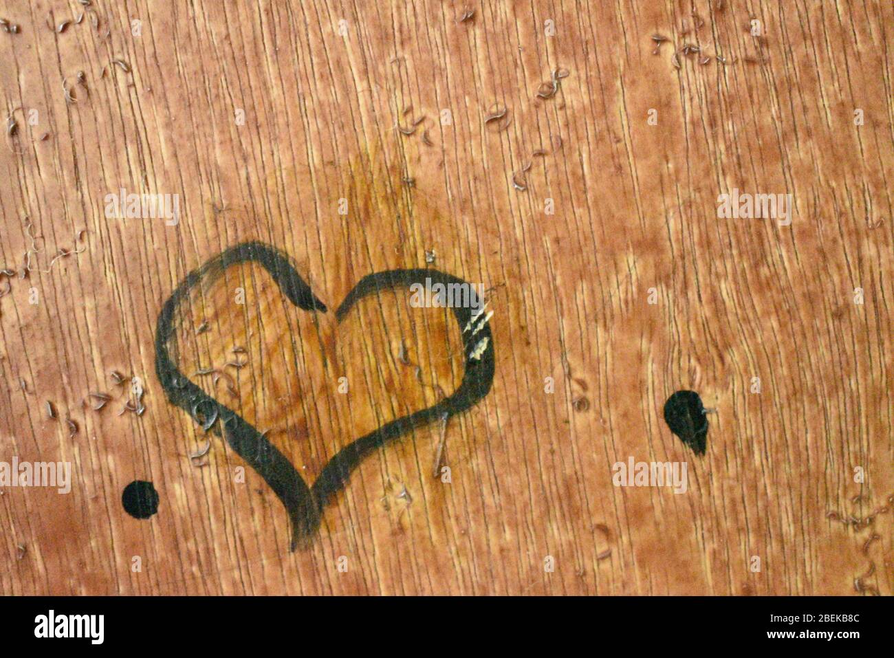 closeup view of heart shape draw by one kid with black paint in brown background door.Day time photography with Nikon camera on april 2020 Stock Photo