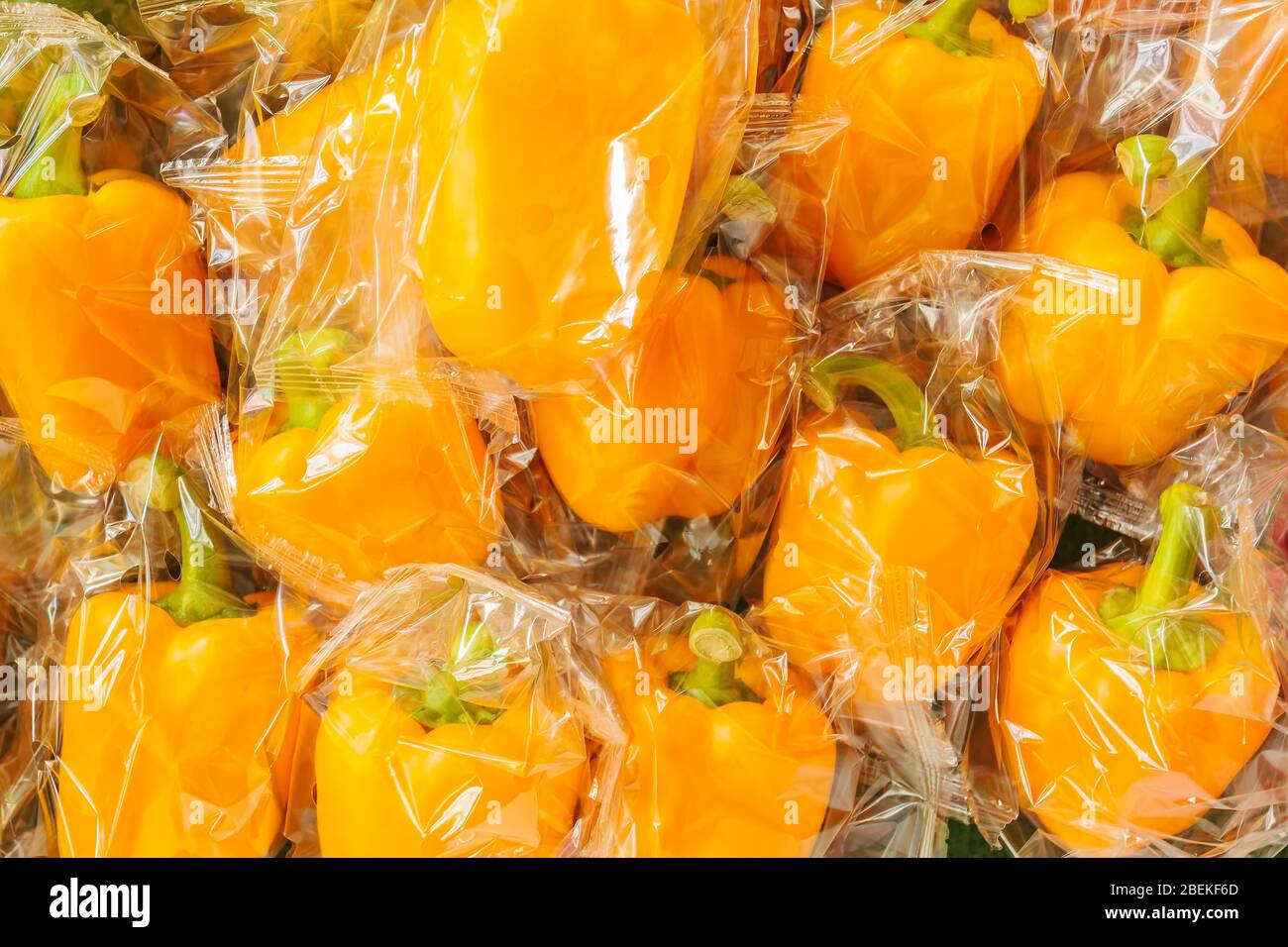 Bunch of fresh plastic wrapped yellow bell peppers Stock Photo