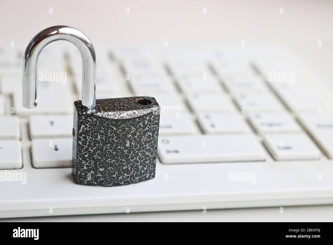 Selective focus Open lock on a white keyboard. Cybersecurity concept. Security Lock. Stock Photo