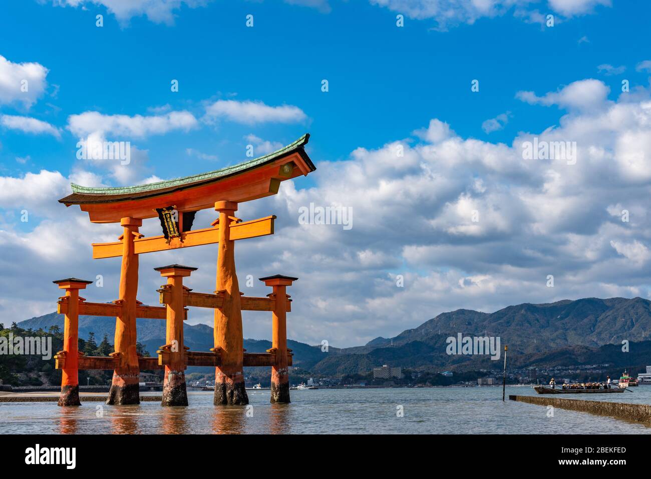 Floating orange red giant Grand O-Torii gate stands in Miyajima island bay  beach at low tide in front of Itsukushima Shrine on sunny day. Hiroshima  Stock Photo - Alamy