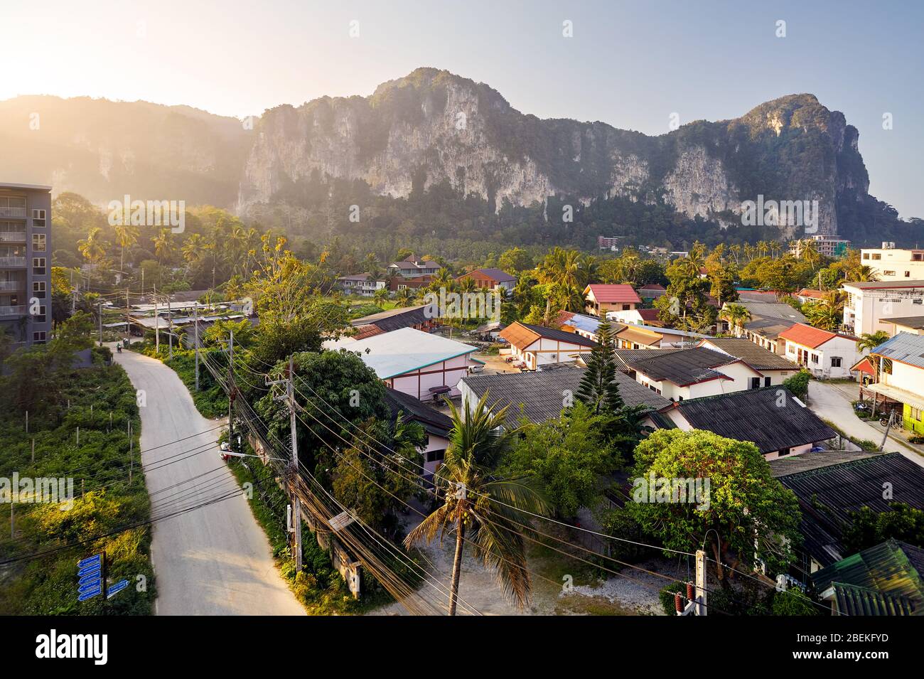 Ao Nang Tropical village with Hotel and small houses at rock mountain background at sunrise in Krabi province, Thailand Stock Photo