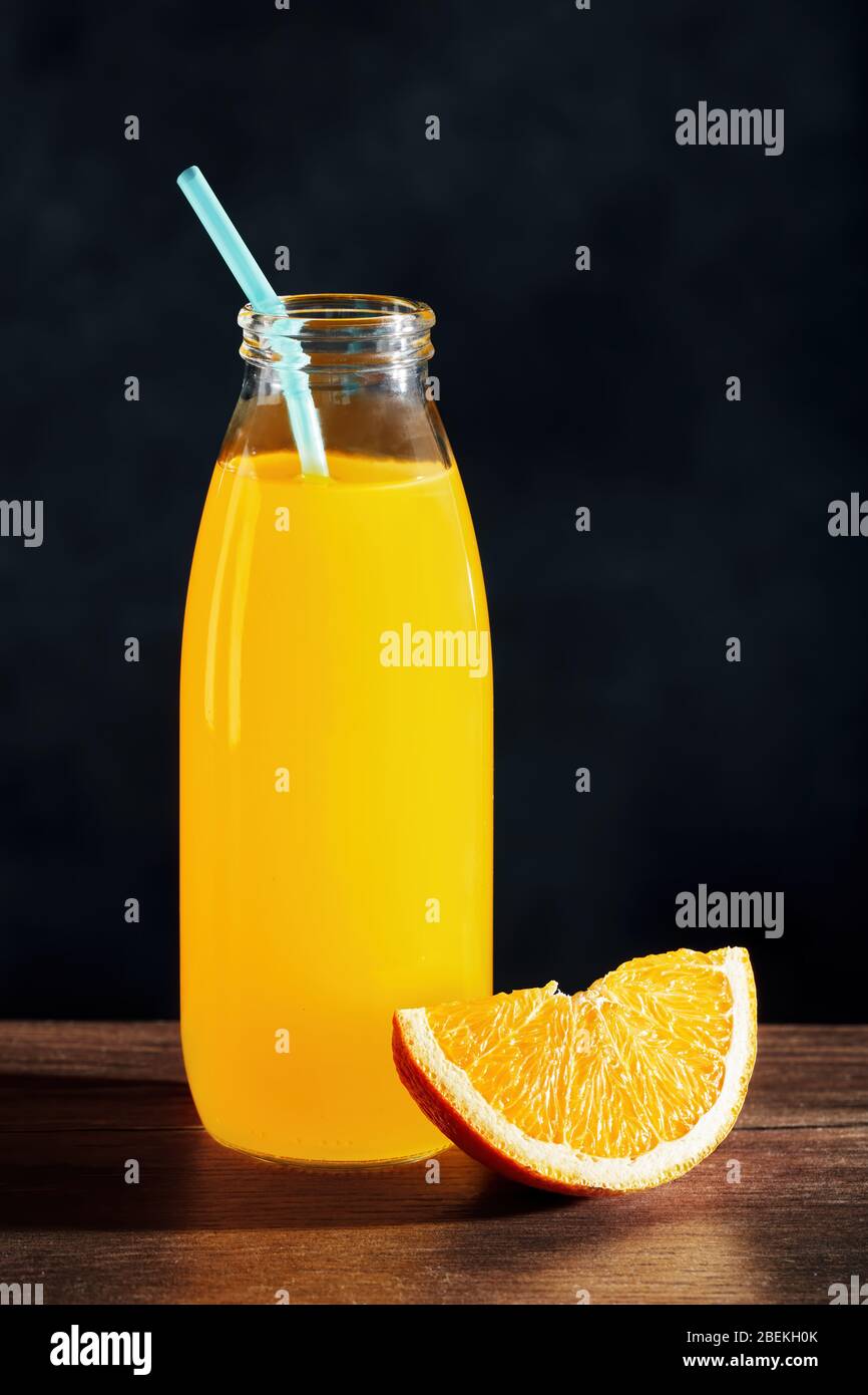 Orange Juice In A Glass Bottle With Straw And An Orange Slice On Wooden Table With Black Background Stock Photo Alamy