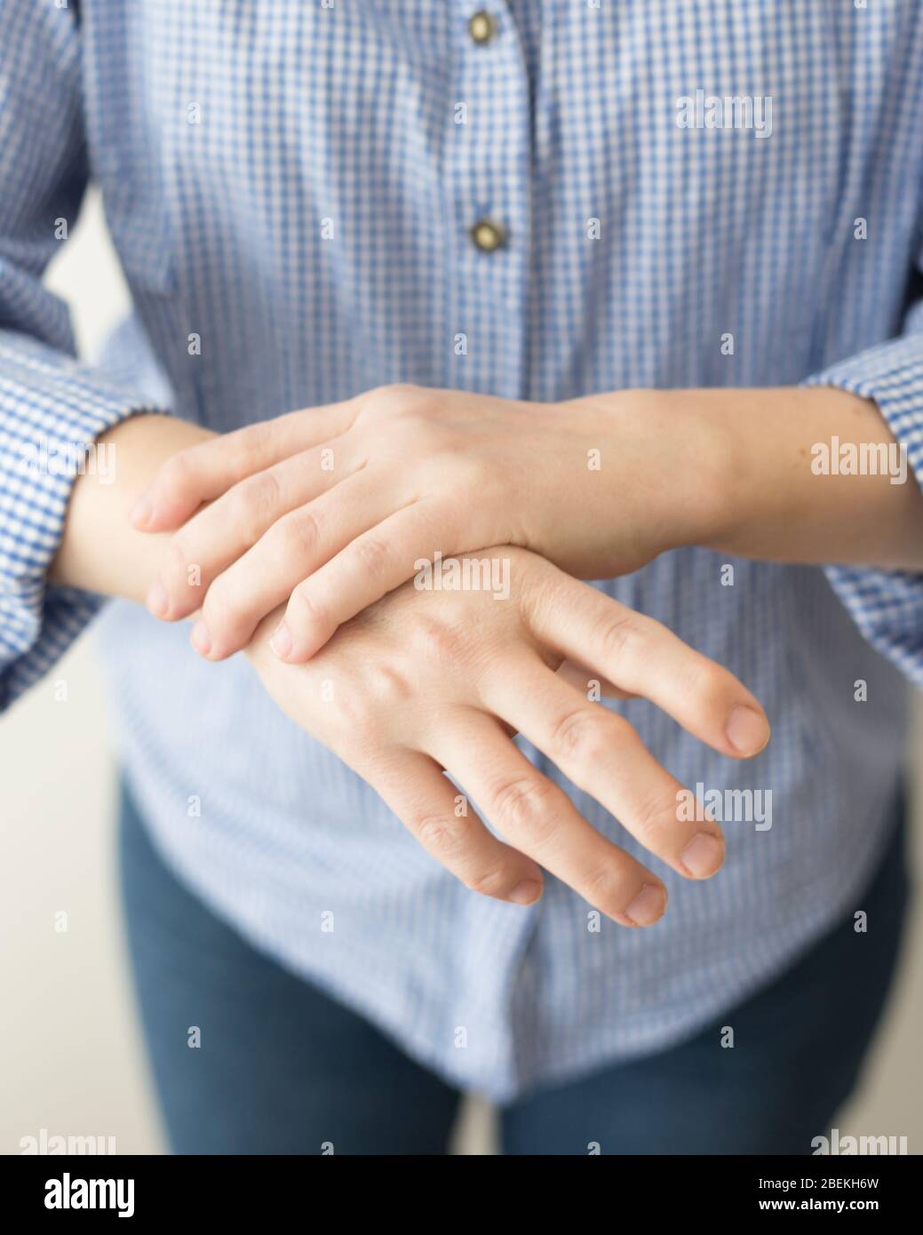 Young caucasian woman or white girl suffering from pain in hands. Health care concept with real rheumatoid arthritis disease deformed fingers and hand Stock Photo