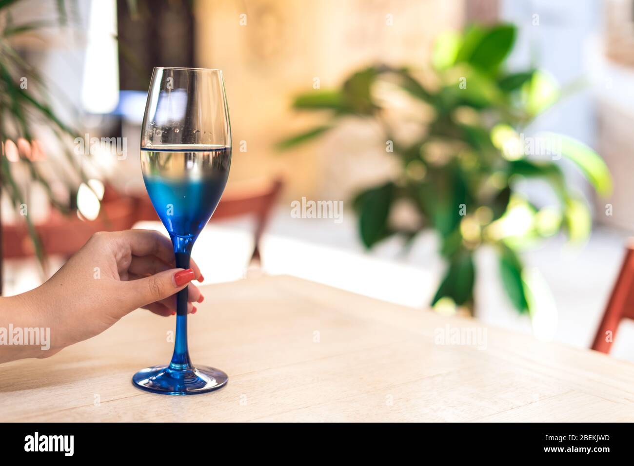 https://c8.alamy.com/comp/2BEKJWD/female-hand-holding-a-glass-of-white-wine-female-hand-with-red-manicure-2BEKJWD.jpg