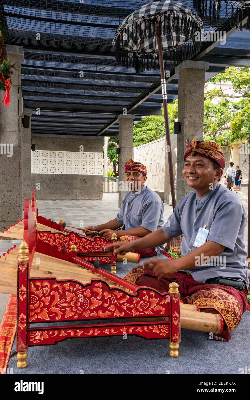 Vertical portrait of musicians playing traditional bamboo xylophones in
