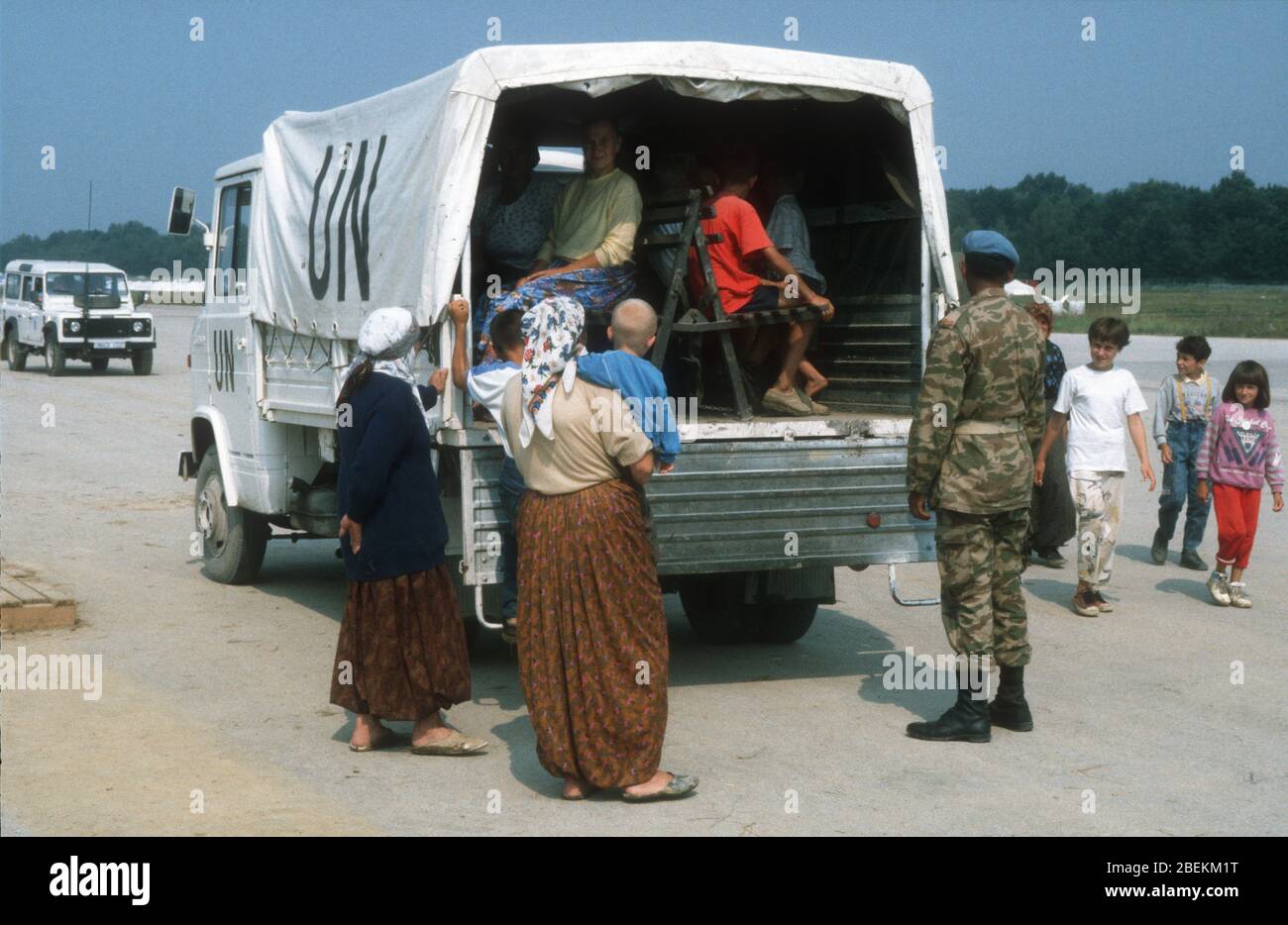1995 Tuzla - Tuzla airfield UN temporary refugee camp for Bosnian Muslims fleeing the Srebrenica Massacre during the Bosnian war. Vehicle collecting refugees pictured. Stock Photo