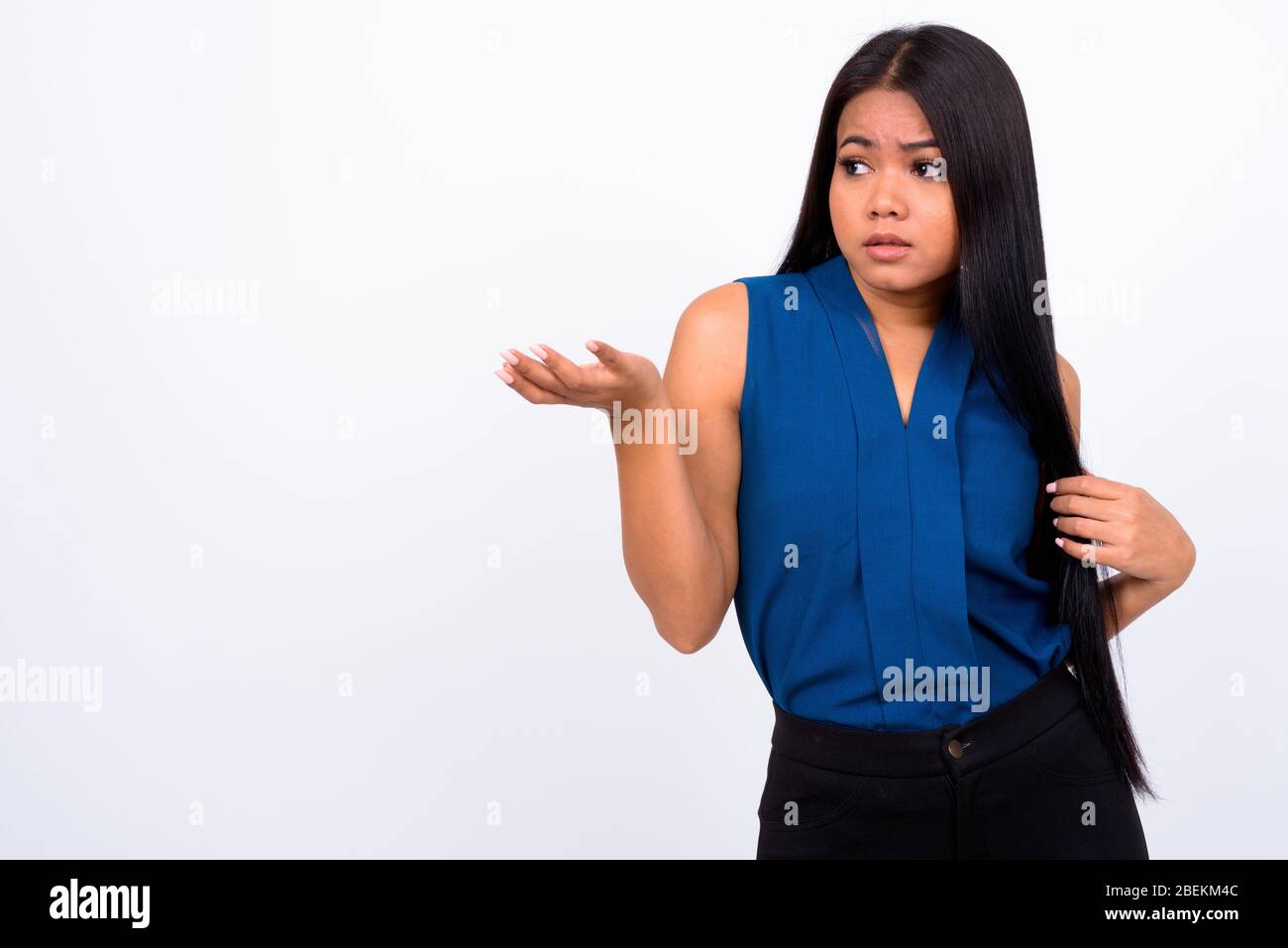 Portrait of young Asian businesswoman shrugging shoulders Stock Photo