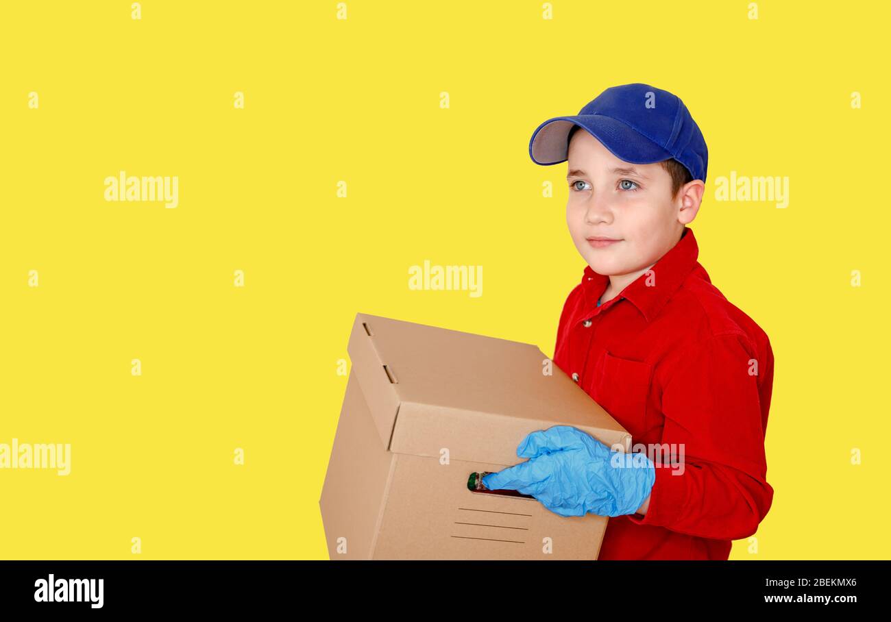 Delivery man employee in blue cap in gloves hold empty cardboard box Stock Photo