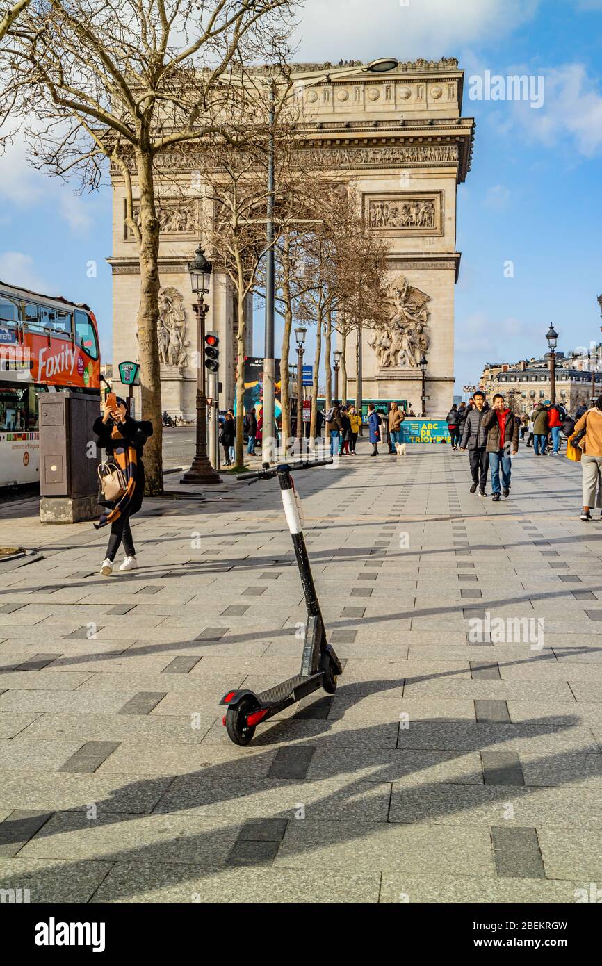 A hired electric scooter left in the middle of the pavement in front of the Arc de Triomphe, on the Champs-Élysées, Paris, France. February 2020. Stock Photo